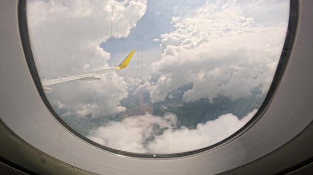 Aerial view through airplane window above clouds, Clark to Malay Philippines