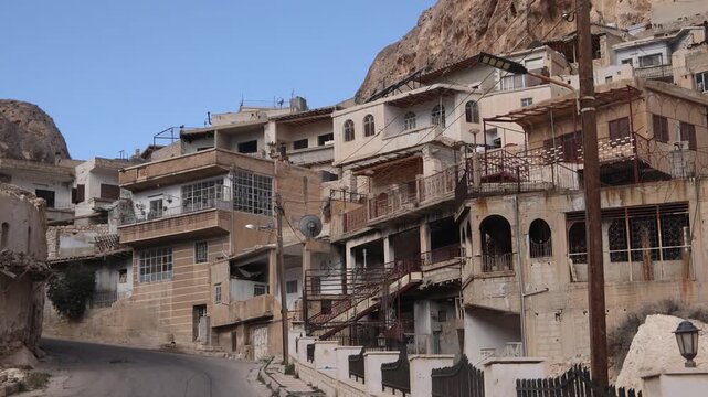 Street level view of the ancient town of Ma'aloula, Syria. Traditional architecture nestled under the massive limestone cliffs of this historic religious site