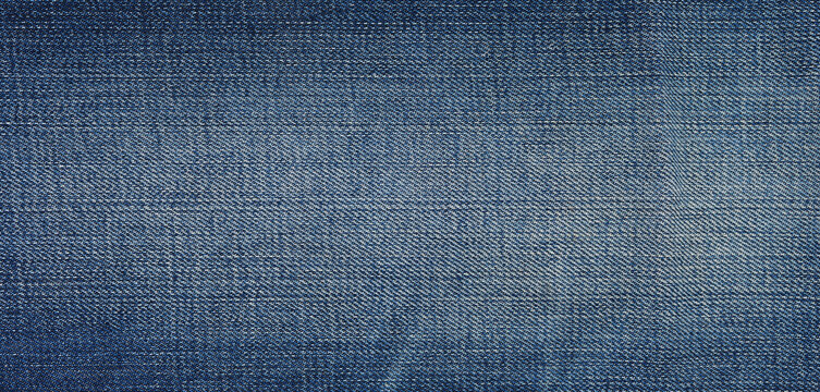 Blue denim fabric texture with faded effects. Close-up jeans background.
