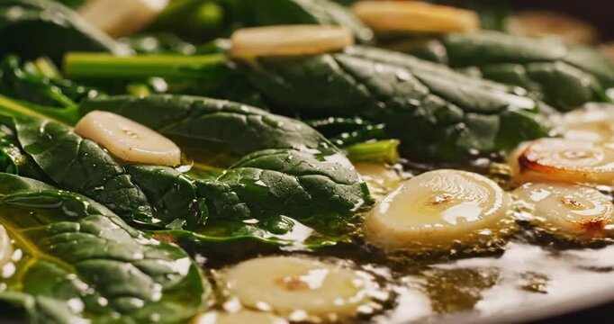 Fresh spinach and garlic saut?ed in olive oil, showcasing vibrant colors and textures