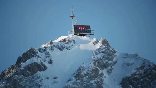 Snow Covered Mountain Summit With Solar Panel Array.