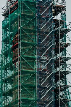 City hall tower under renovation with construction scaffolding, reconstruction work, historic building