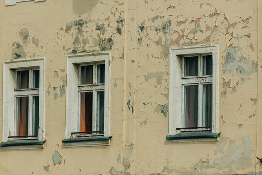 Eastern Europe 19th century houses, crumbling facade, cracked plaster and paint, neglected old town center.