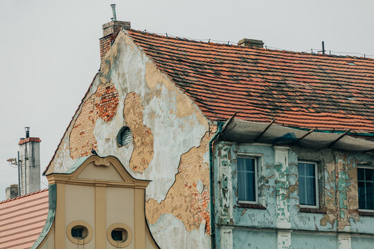 Eastern Europe 19th century houses, crumbling facade, cracked plaster and paint, neglected old town center.