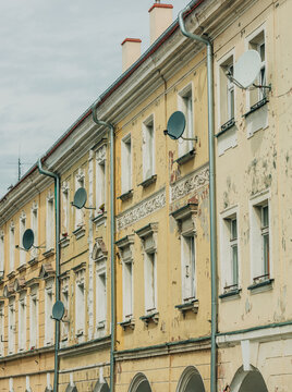 Eastern Europe 19th century houses, crumbling facade, cracked plaster and paint, neglected old town center.