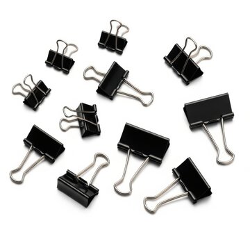 Assorted black metal binder clips scattered on a white background