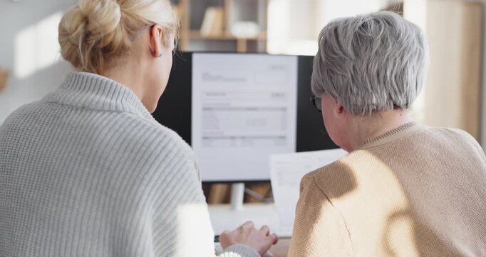 Daughter help senior woman finance invoice payment. At home they review bills and tax on a screen, organizing expenses and planning budgets. Clear concept family finance help at home today.