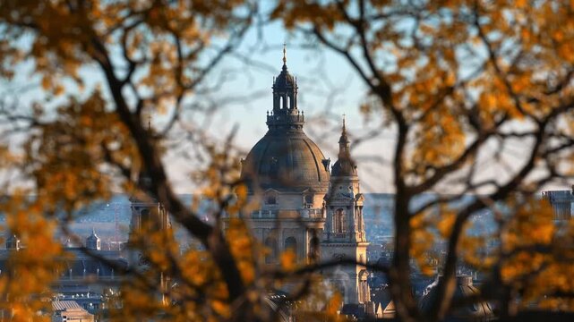 Beautiful autumn day view of budapest st stephens basilica with golden leaves in foreground cinematic footage.