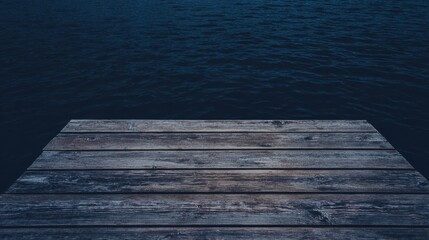 Fototapeta premium Top view of a rustic wooden dock extending over a dark blue lake, the wood texture fills the foreground, empty water in the background