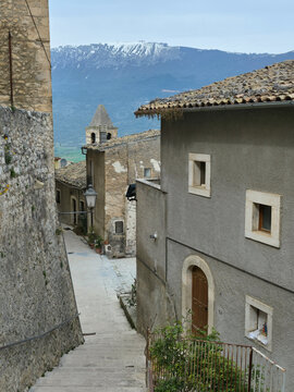 Narrow Stone Alley in Capestrano Village with Snow-Capped Mountains Background, Abruzzo, Italy