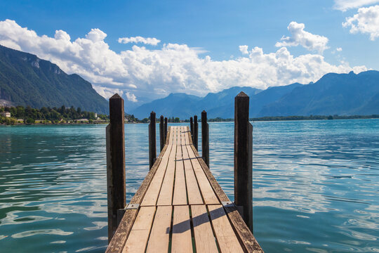 Wooden pier overlooking the Swiss Alps and Lake Geneva in Switzerland