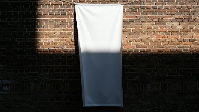 A blank white banner hanging on a weathered brick wall with sunlight and shadows present