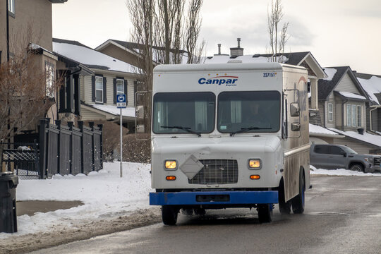 Calgary, Alberta, Canada. April 13, 2026. A white Canpar Express delivery truck drives through a snowy residential neighborhood.