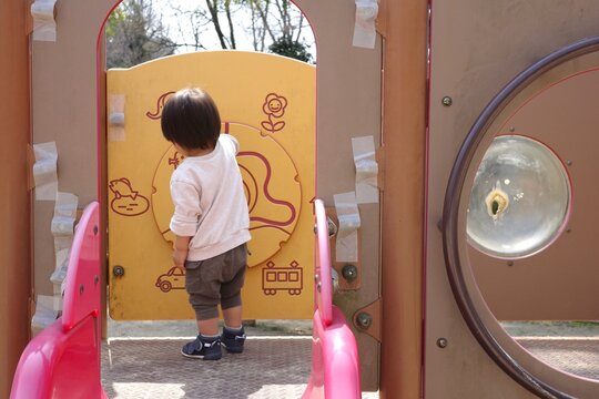 Back View of a Toddler Playing with Educational Panels at a Park