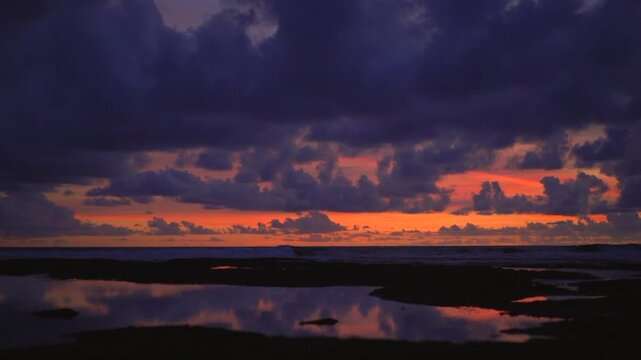 Purple and orange sunset over basalt reef at Echo Beach