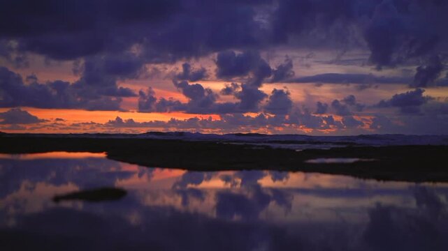 Purple and orange sunset over basalt reef at Echo Beach