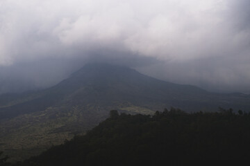 Fototapeta premium Moody tropical volcano peak shrouded in storm clouds in Bali