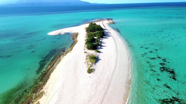  Pristine tropical island sandbank stretching into clear blue ocean water.