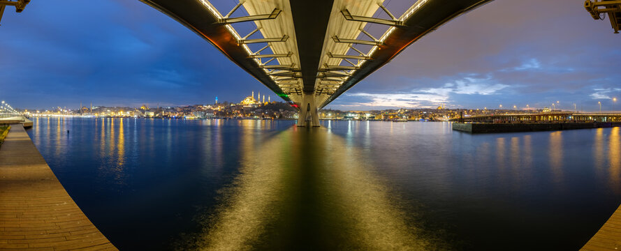 Golden Horn ( Halic ) Metro Bridge and historic Suleymaniye Mosque skyline at dramatic dusk