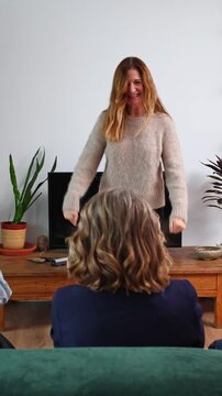 Group of senior women friends playing charades at home