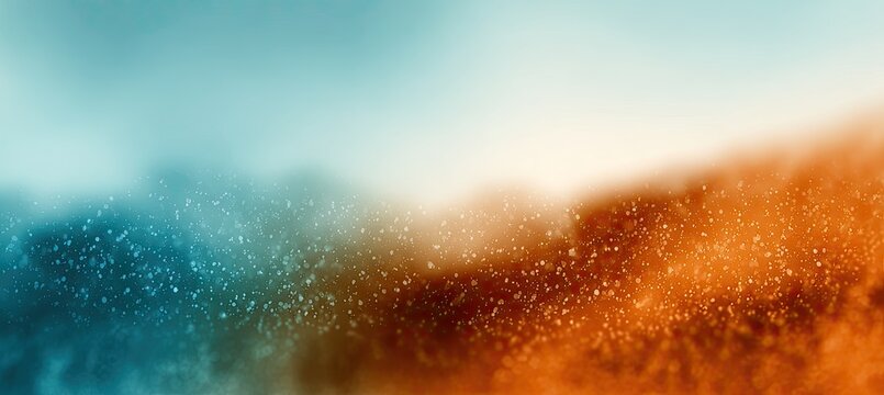 A vibrant, blurred gradient transitions from cool teal to warm orange, speckled with sparkling particles.