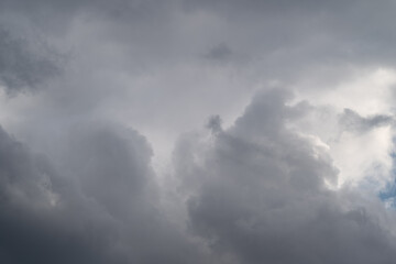 Obraz premium Heavy gray clouds gather low, dense textured layers create tense atmosphere and sense of approaching storm, powerful backdrop for news, safety, or climate visuals