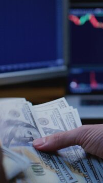 Close up: man trader or businessman counts salary usd banknotes at home with his hands. Male entrepreneur holds stack of dollar bills in palms, keeps money records for budget. Counting american paper
