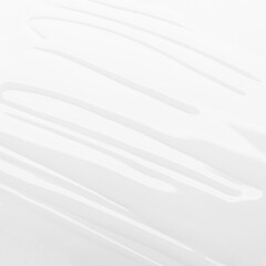 Obraz premium Abstract glossy texture of white liquid cosmetic serum or lotion seamless background with soft smooth waves