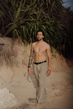 Shirtless tattooed man by pandanus, Nyang Nyang, Bali