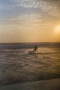 Kitesurfer spraying water at golden sunset, Batu Bolong Beach, Canggu