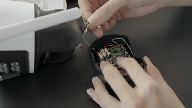 Close-up, Hand of woman repairing a wireless CCTV camera