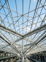 Fototapeta premium Upward view of a geometric glass and steel ceiling in a modern transport hub. Bright architectural space with copy-space.