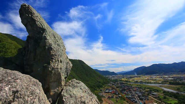 比丘尼石と流れる雲と千曲川