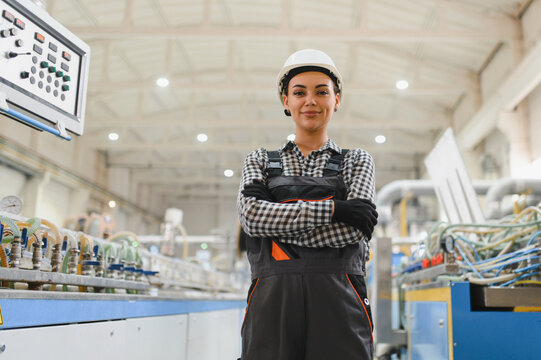 Female factory worker smiling with crossed arms in pvc manufacturing plant