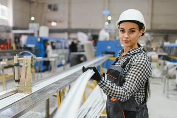 Female factory worker holding pvc window frame in manufacturing plant