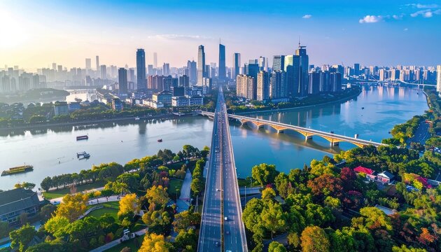 An aerial view showcases a sprawling cityscape nestled along a winding river, connected by a modern bridge bathed in the warm glow of sunrise.