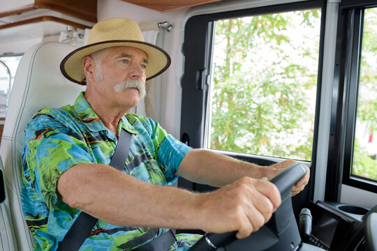 senior man driving on a road in the camper van