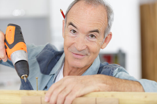 a happy senior carpenter at work