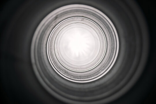 Metal, pipe and light with spiral circle of tunnel, tube or pattern for abstract design or frame. Empty, texture or steel hole with swirl, passage or bright end of pipeline, exit or round object