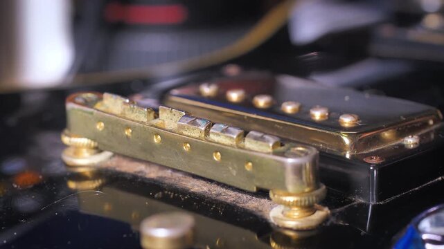 Close up shot the hand using microfiber fabric to clean the fret board of electric guitar 