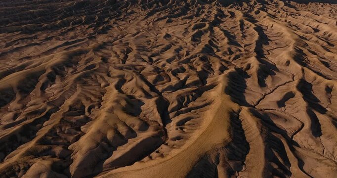 Abstract aerial patterns of eroded desert ridges in Utah badlands terrain, tilt up to Factory Butte