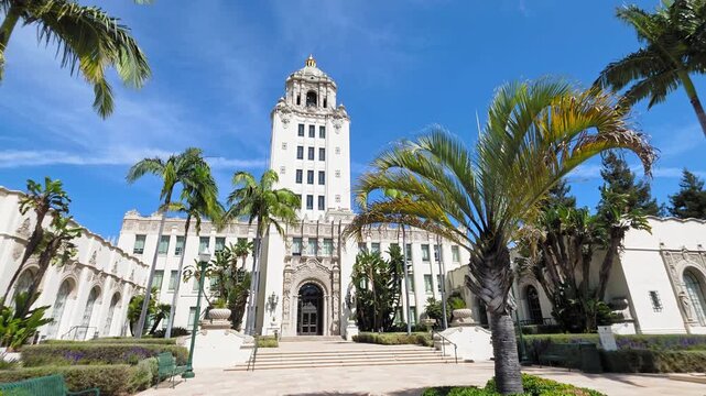 Beverly Hills City Hall framed by palms under vivid blue sky, Elegant civic landmark with ornate tower and manicured courtyard in bright daylight