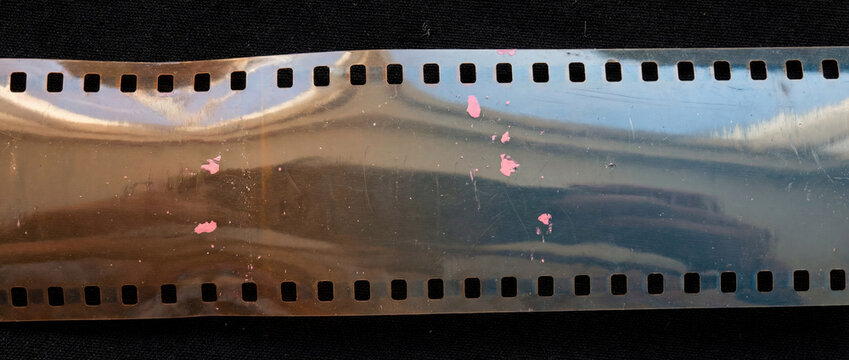 Damaged 35mm Film Strip with Light Leaks and Scratches on Black Background