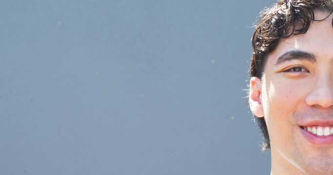 Man entering frame from right, smiling while holding half-face pose for marketing