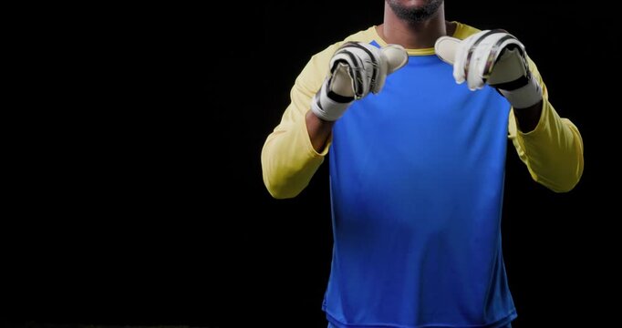 African American man holding hands near chest, moving gloves forward in studio training in blue kit