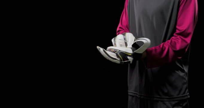 Man wearing pink jersey holding gloves, putting on straps preparing for match in studio, copy space