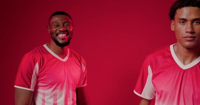 African American men in kit holding soccer ball on red set camera pulling stepping forward closeup