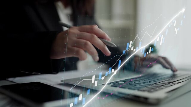 A business professional engaged in financial data analysis on a laptop while monitoring market trends with a smartphone in a sleek office setting. Copula