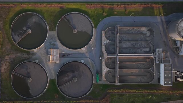 Aerial view of the water treatment facility showcases the circular tanks and filtration systems, reflecting the light of the setting sun, Lisbon, Portugal.
