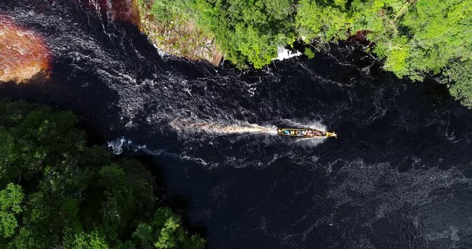 Above View Of Motorboat Sailing Across The Churun River In Canaima National Park In Venezuela. Aerial Drone Shot